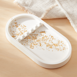 White slippers with gold glitter on a beige surface