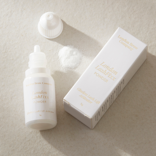 White lash lifting glue powder product bottle and packaging on a beige background