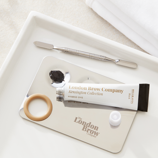 London Brow Company hybrid dye tube with applicator on a white tray
