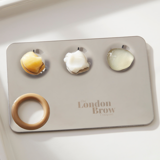 Set of eyebrow products on a tray with 'The London Brow' branding.