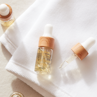 mini brow and lash aftercare serum on a white cloth background flat lay