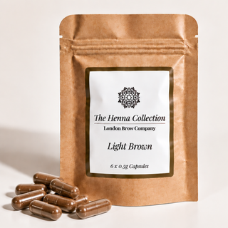 A stand-up kraft paper pouch labeled 'The Henna Collection' and 'London Brow Company' with 'Light Brown' and '6 x 0.5g Capsules' printed on the front.
