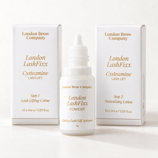 London LashFixx Cystamine Lash Lift set by London Brow Company, featuring a central white bottle of powder with a dropper cap, flanked by two white boxes containing cysteamine lash lifting creme and neutralising lotion.
