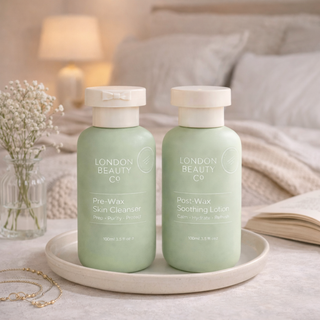 Two green bottles from London Beauty Co on a tray with a soft, blurred background.