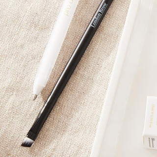 Eyebrow pencil and products on a beige surface with 'London Brow' branding.