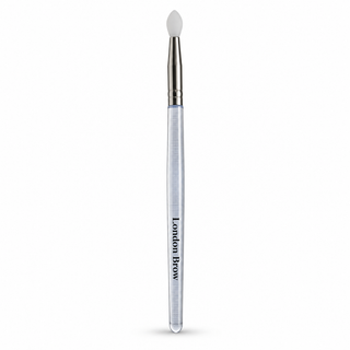 A London Brow eyebrow pencil with a clear handle, silver ferrule, and white silicone tip, shown vertically on a white background.