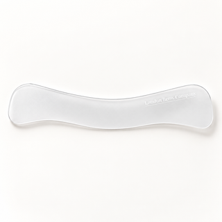 A clear plastic brow lacerator tool with the brand name 'London Brow Company' printed in white on the right side, shown on a clean white background.