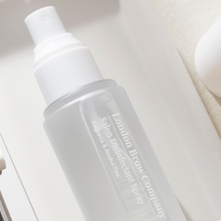 White bottle of Salon Disinfectant Spray from London Brow Company on a light background