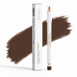 London Brow Company KermiInfusion Collection eyebrow pencil in a white tube with a brown tip, standing next to its white packaging box, with a brown eyebrow swatch smear behind them on a white background.